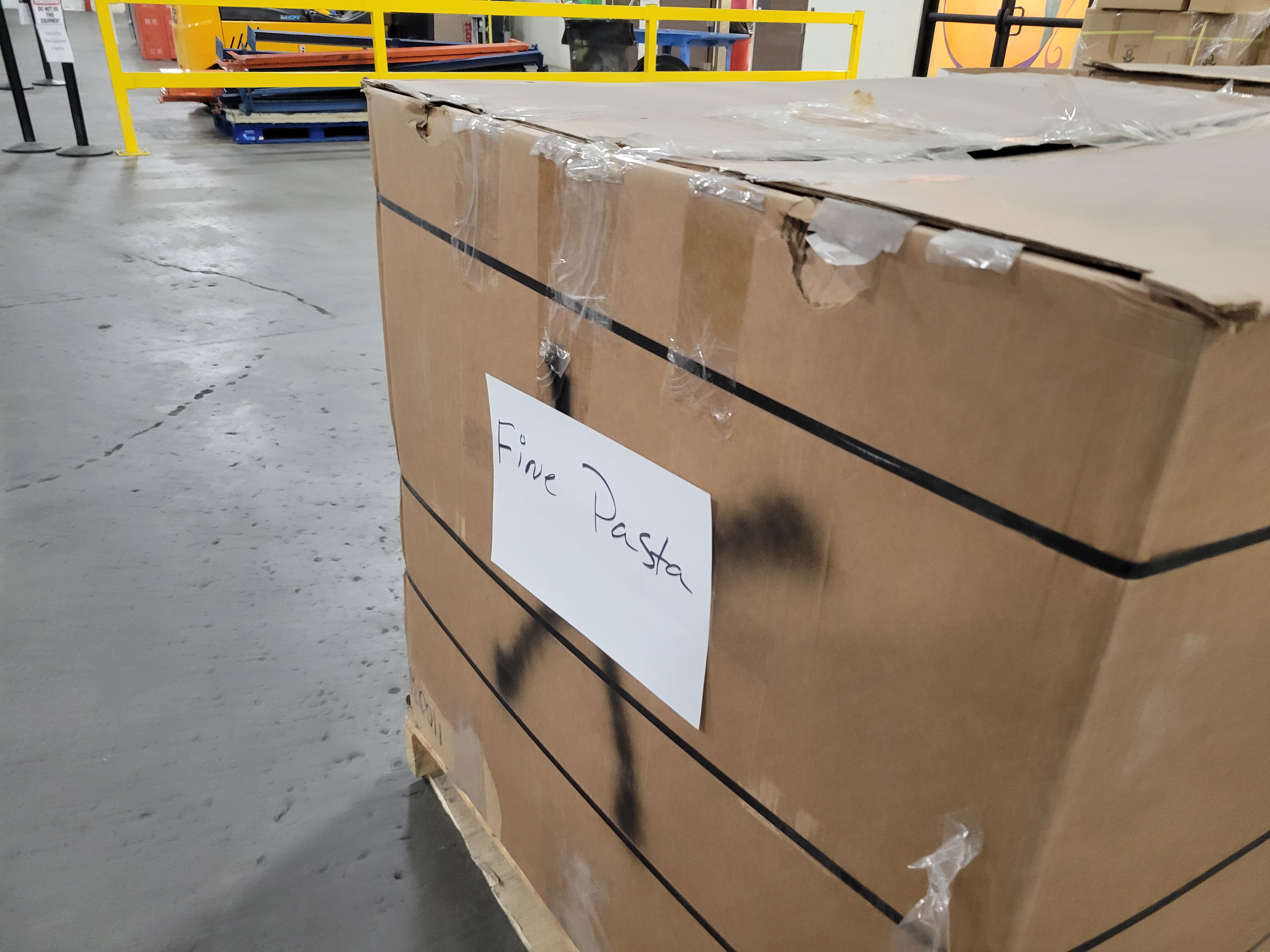 Taped shut cardboard container with a sign that says fine pasta.